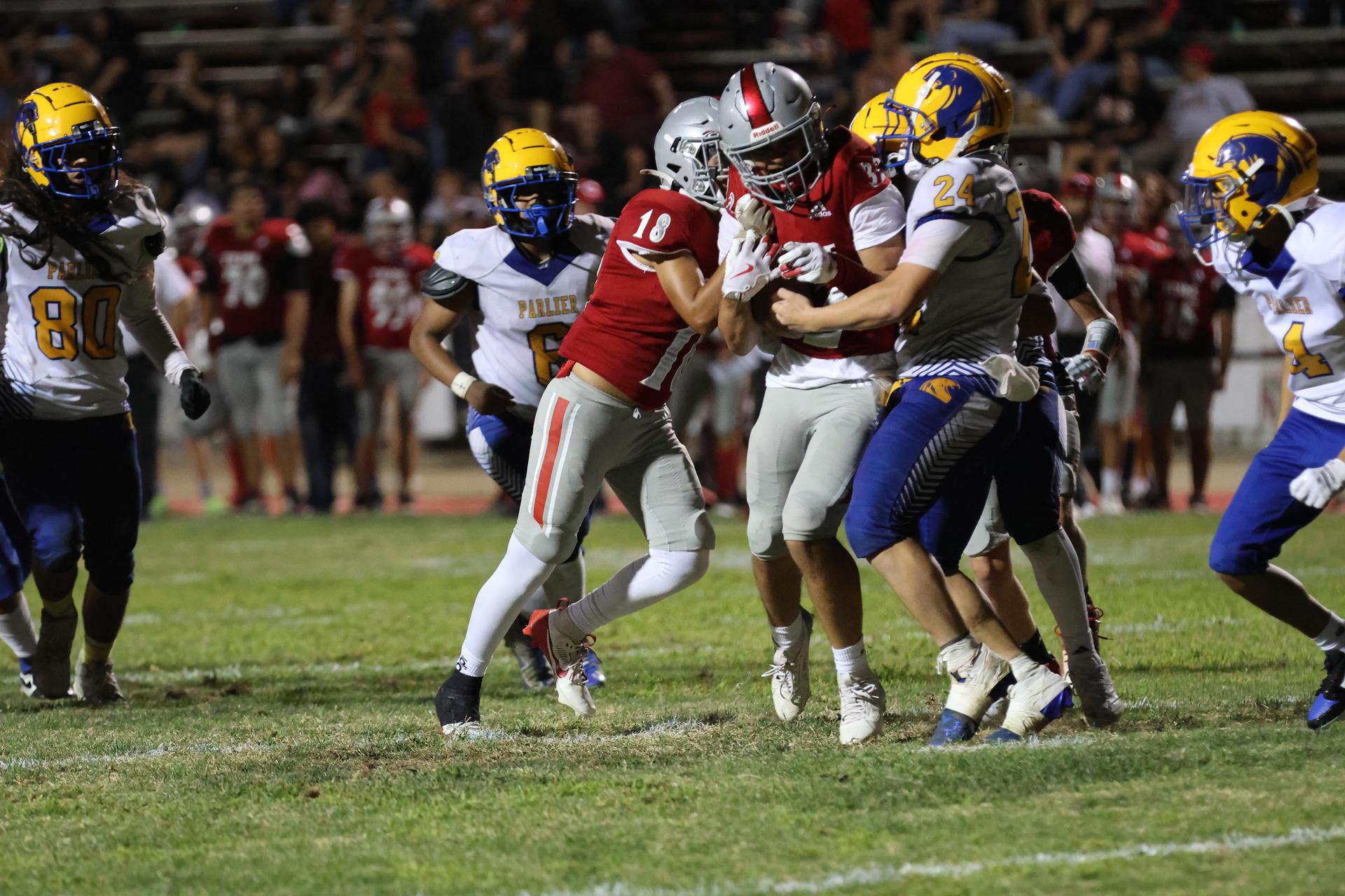 Varsity football players in action against Parlier 114