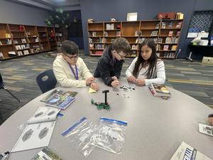 Three students at Ridgewood working to assemble the most recent LEGO build project