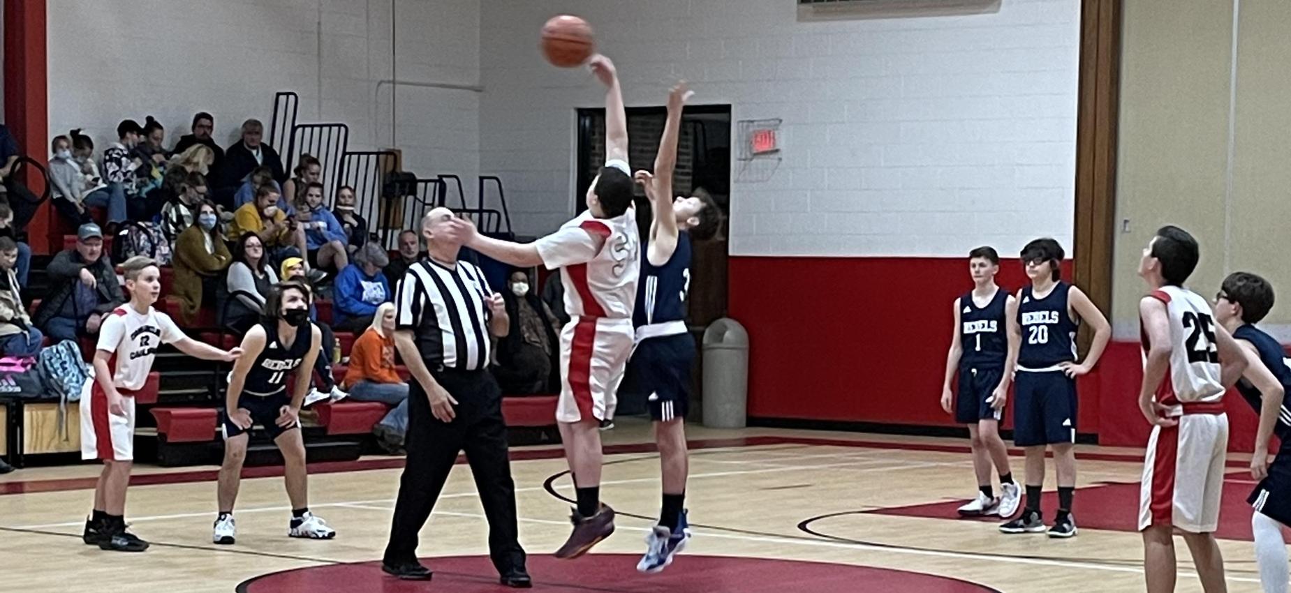 Two basketball players jump during a tip-off.