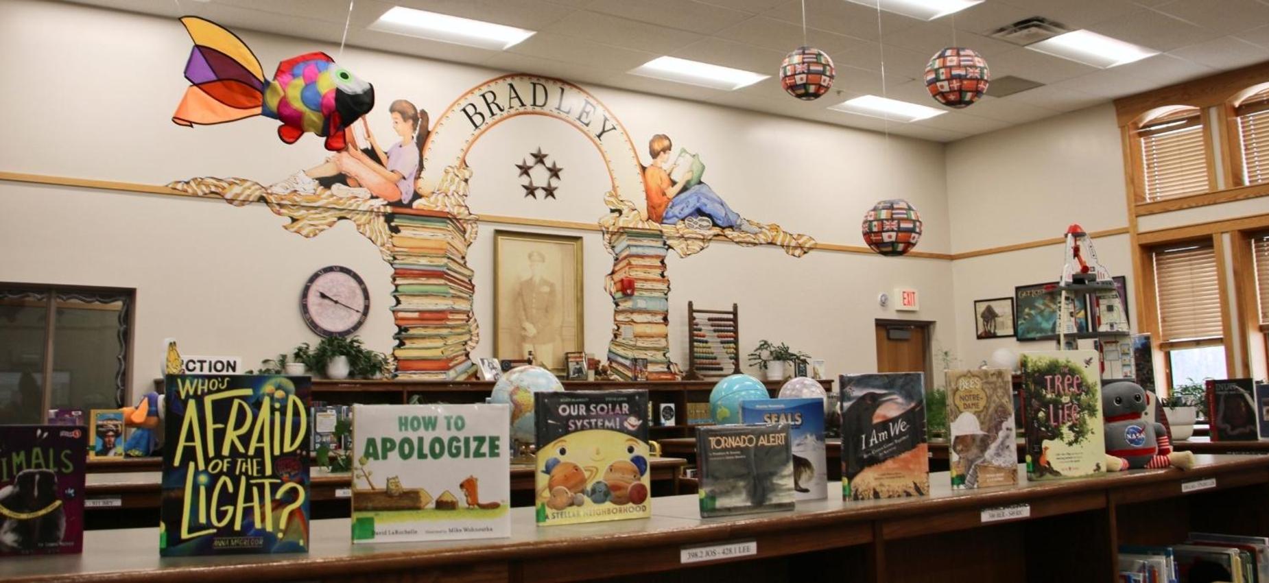 A library scene with books, a mural, and a turtle decoration.
