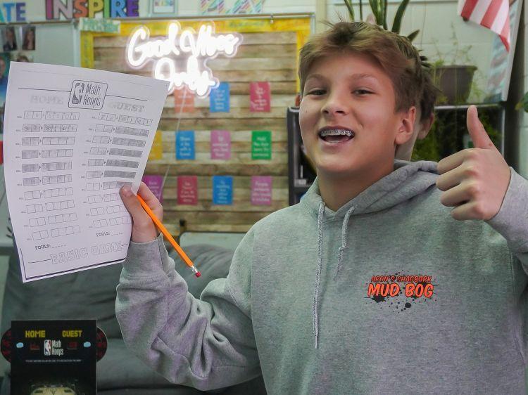 A student gives the thumbs up after making a great move in his game.