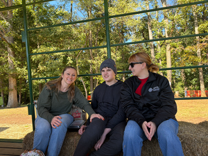 student with parent and staff member on a hayride