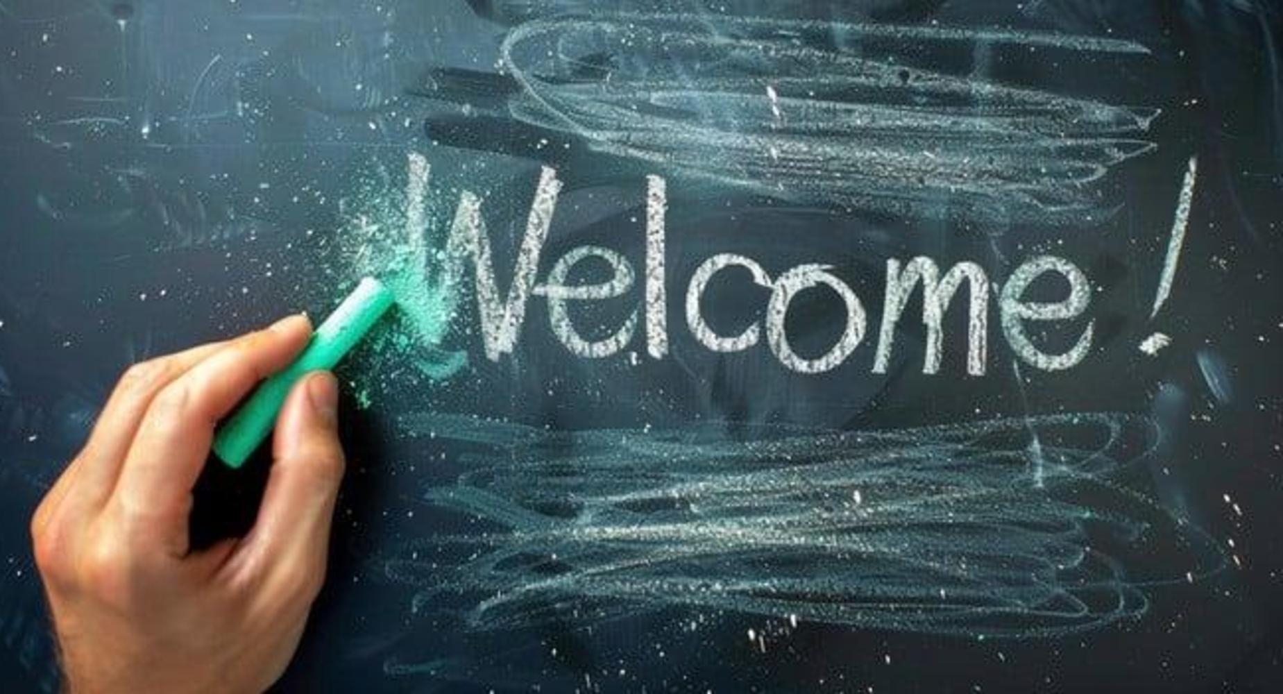 Chalkboard with the word 'Welcome!' written in white chalk and dusting effect.