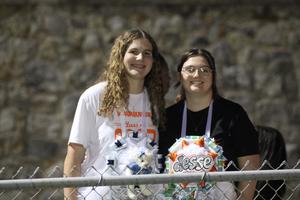 Two young women smiling together with decorative items.