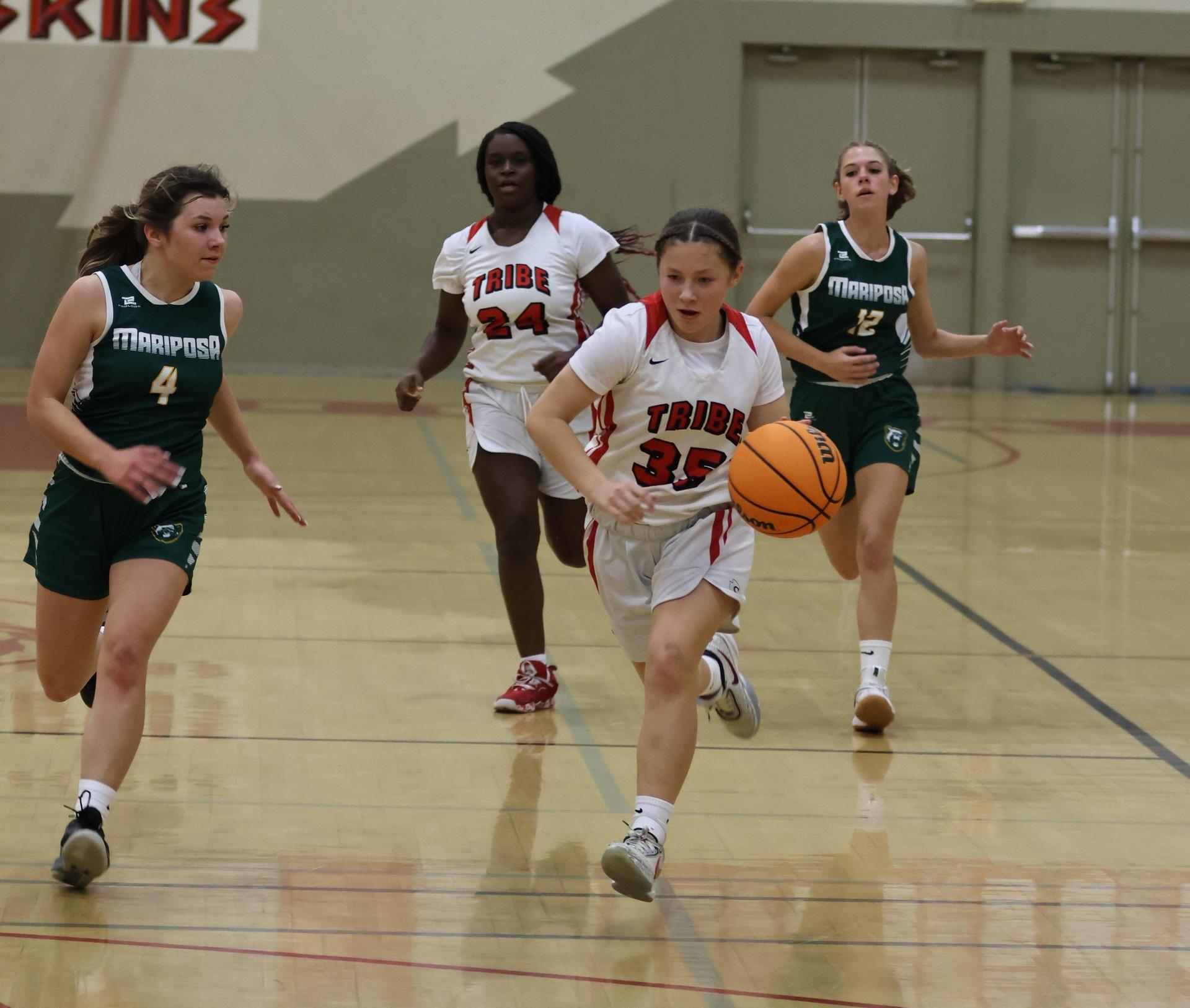 varsity girls playing basketball against mariposa