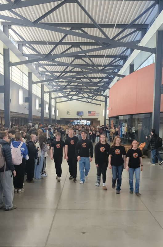 Students walk down the hallway lined by classmates during a state sendoff.