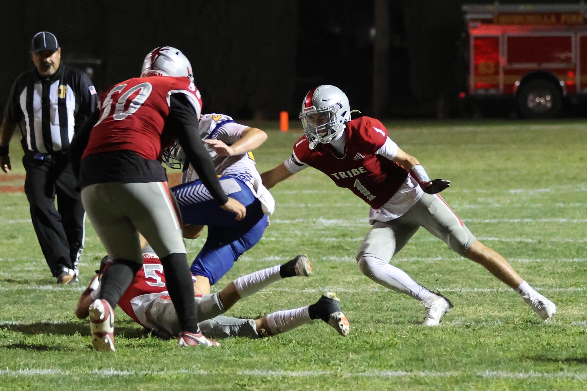 Varsity football players in action against Parlier 80