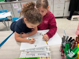 Two girls working on their fire safety poster