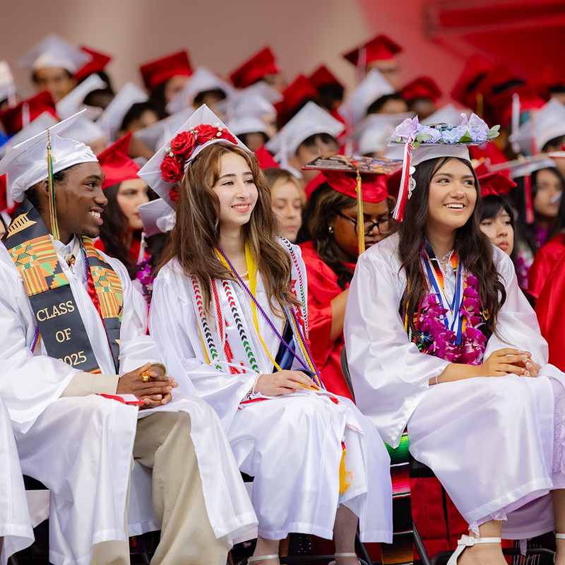 high school graduates in white caps and gowns