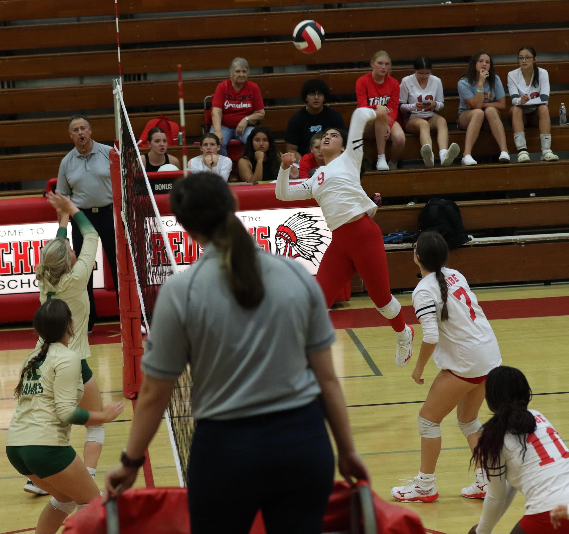 varsity volleyball players in action against liberty