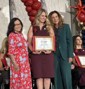 Mrs. Feldman posing with her Teacher of the Year award certificate.