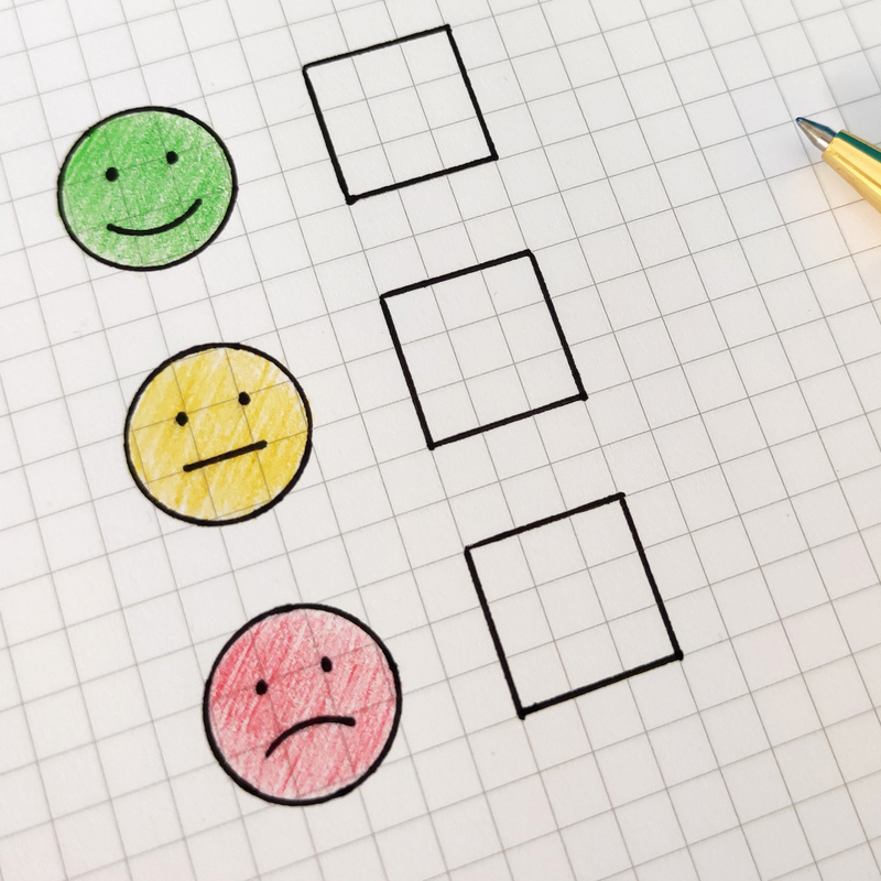 taking a survey with smile, neutral, or frown
