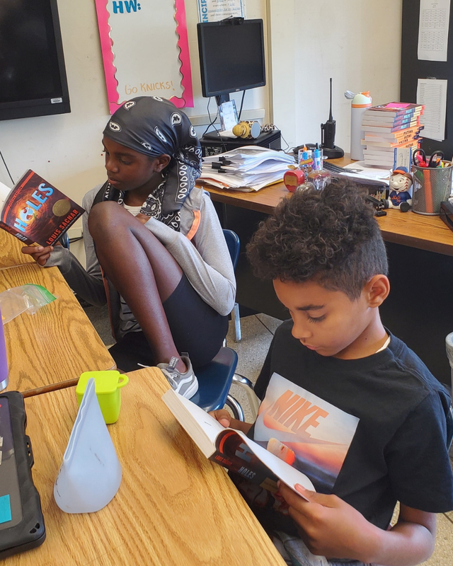 Two RJB students sit quietly reading a book