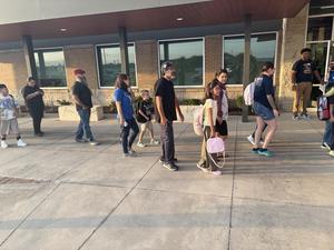 Families line up to enter the school