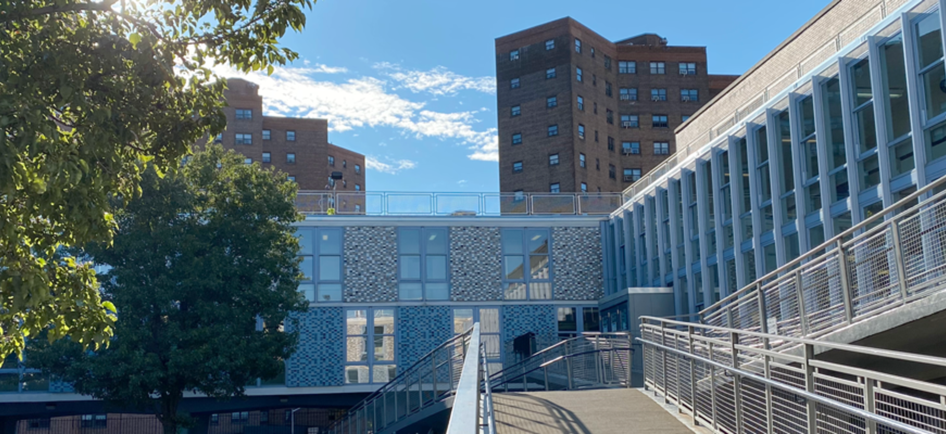 Campus ramp leading to main entrance on a sunny, clear day.