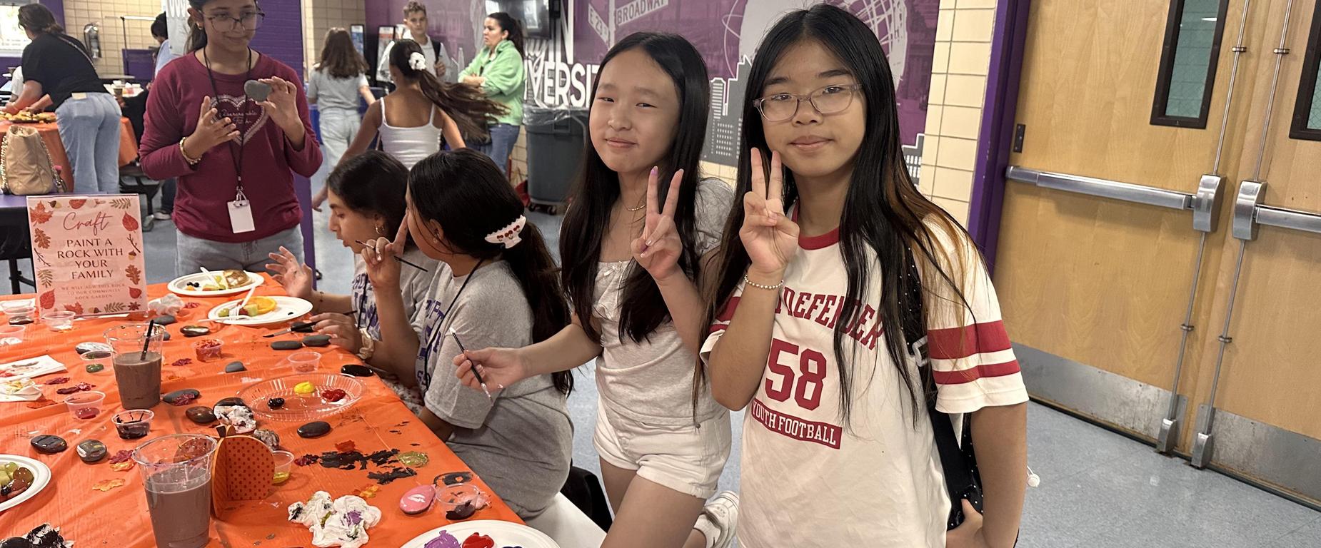 students at table, students with peace sign