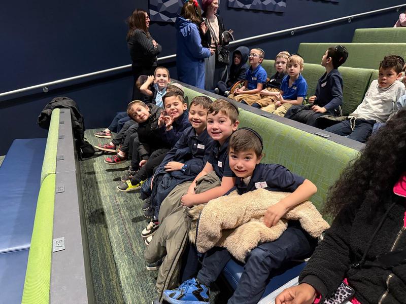 The first grade boys watch a puppetry performance.