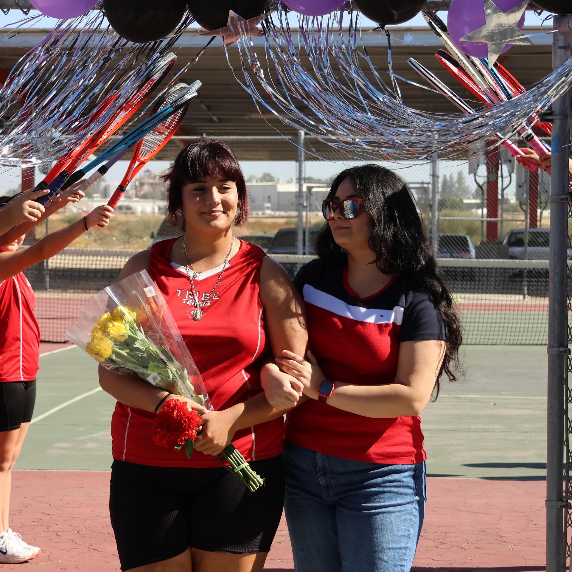 tennis players, family, and staff celebrating senior night