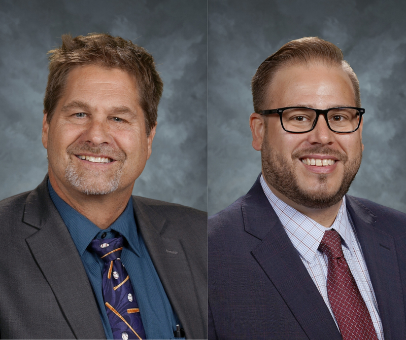 two male administrators dressed in suits smiling at camera