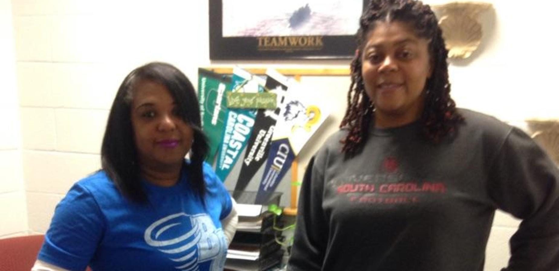 Two staff members wearing college shirts on College Day Wednesday