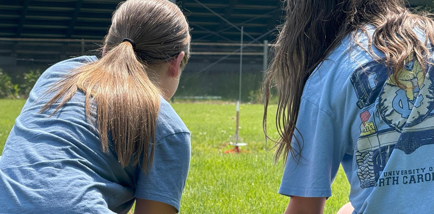 2 girls launching a rocket outside