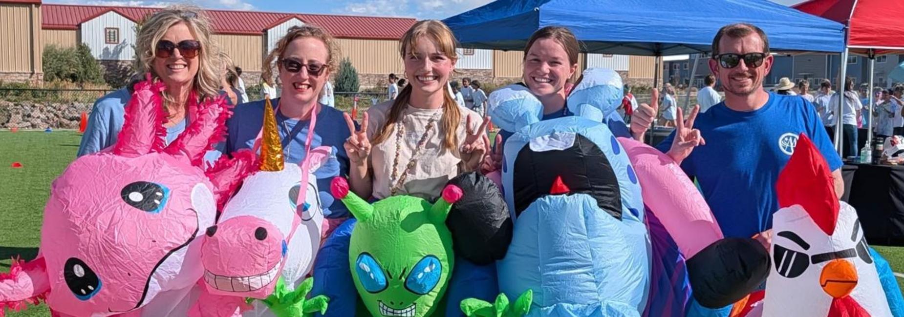 Group of people wearing inflatable costumes at an outdoor event.