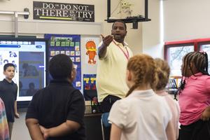 An elementary teacher talks to his students