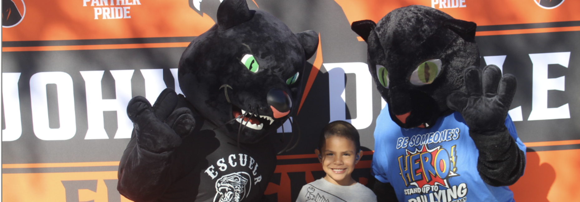 student taking picture with mascots.
