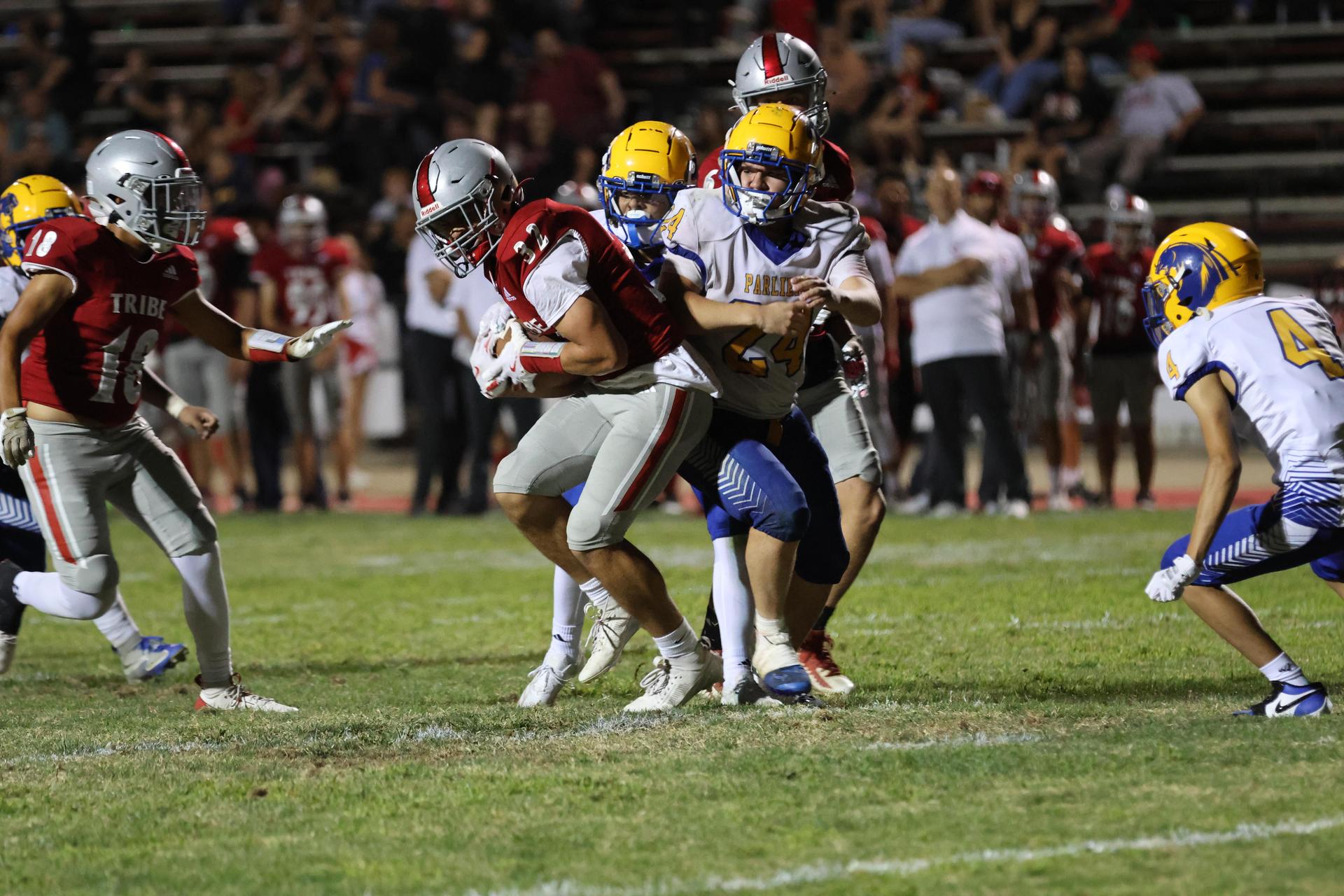 Varsity football players in action against Parlier 110