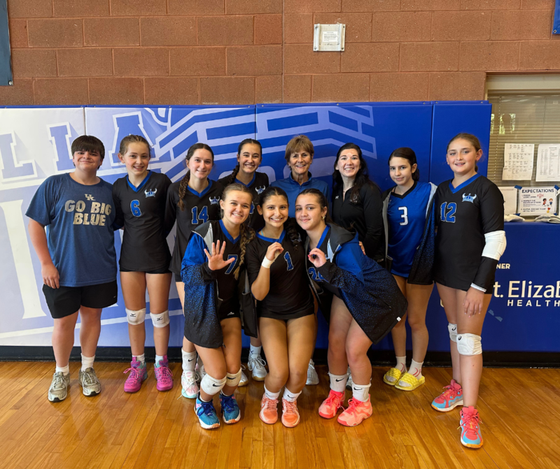 Varsity Volleyball poses with Coach Kitchen to celebrate her 500th win.