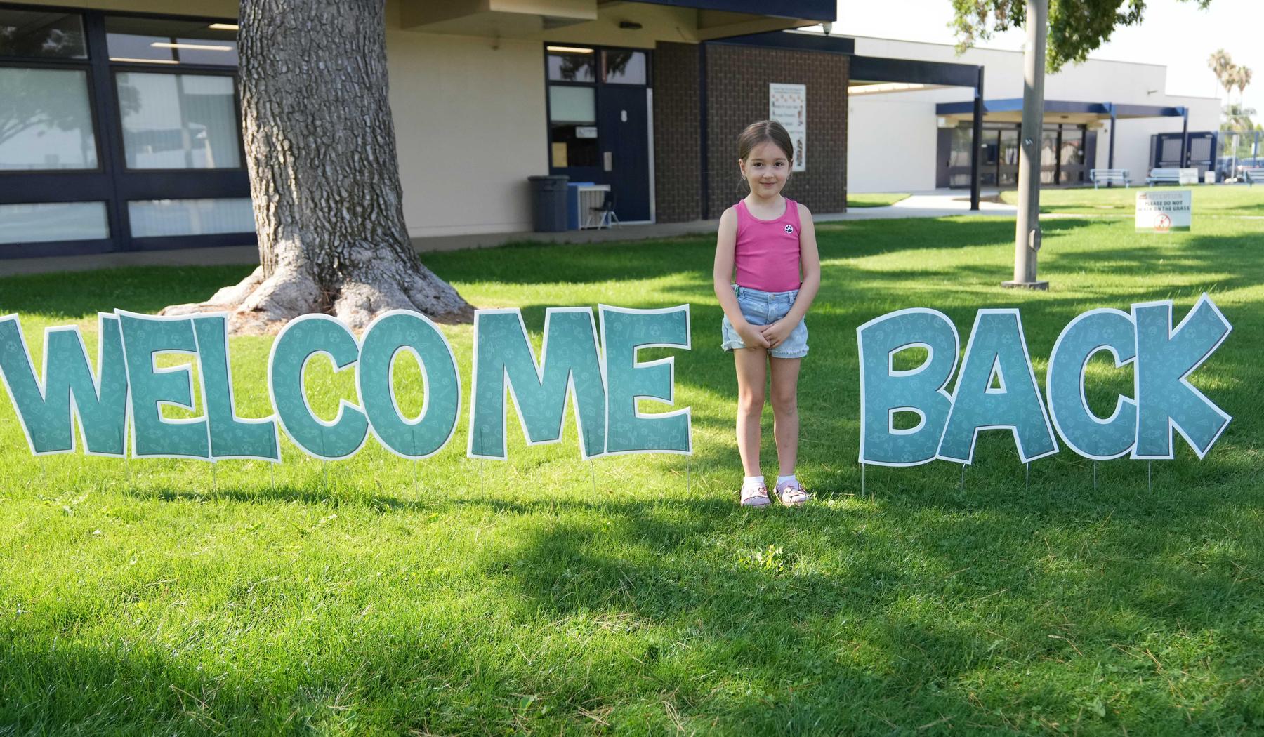 Young student with welcome back sign