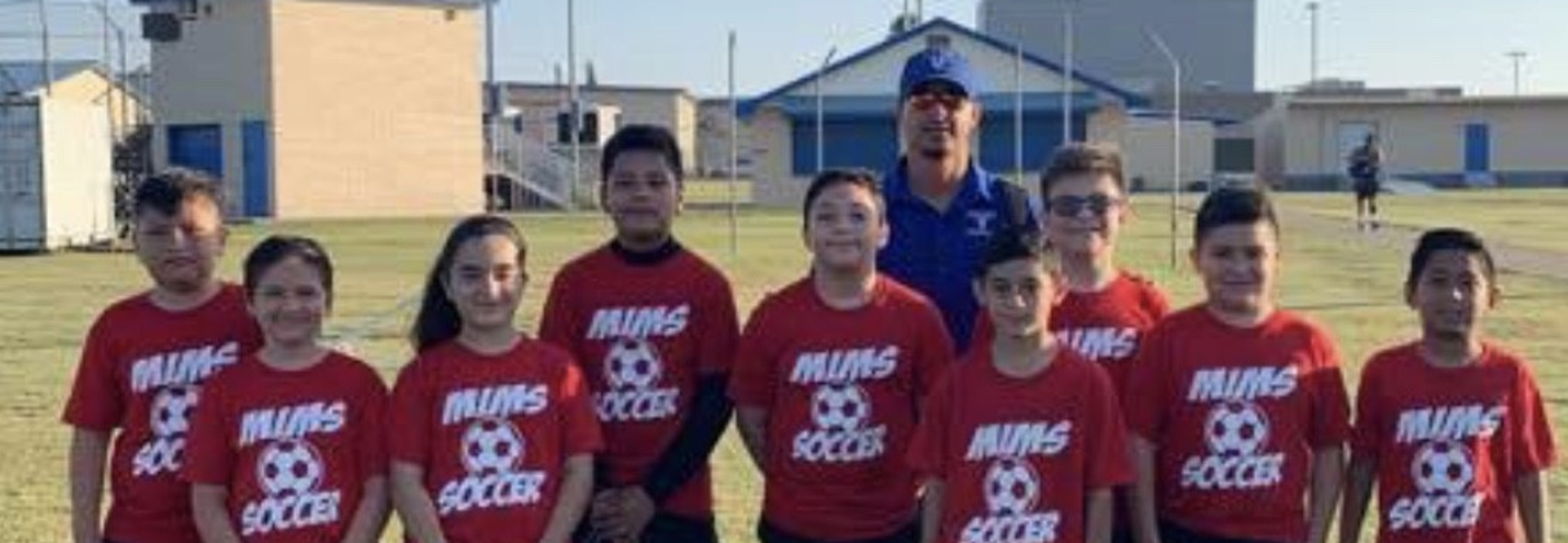 kids and coach wearing soccer shirts