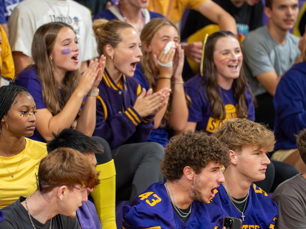Students in Palisades shirts cheering in the bleachers.