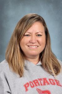 Smiling woman in a gray sweatshirt with long hair.