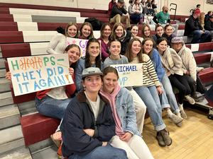 unified basketball game classmates sit in stand and hold posters in support