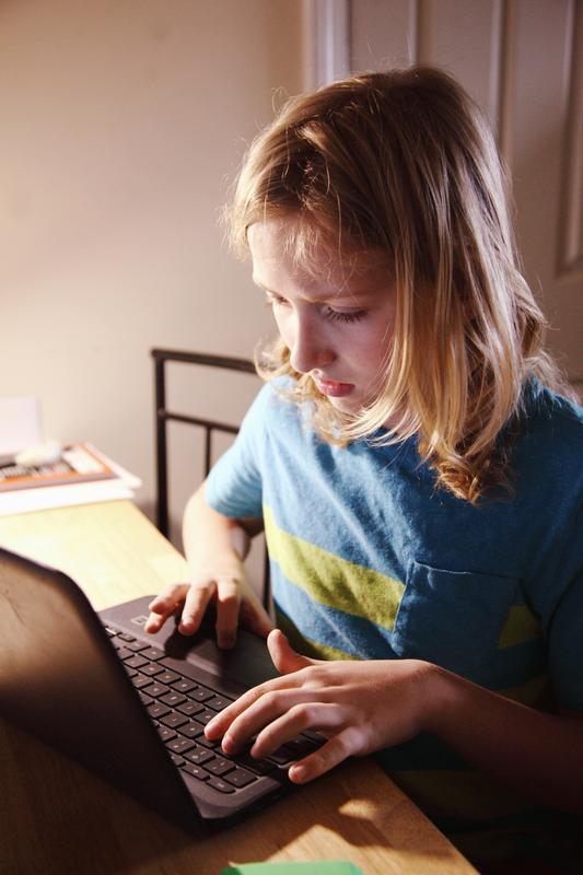 Student typing on laptop