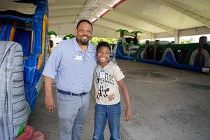 A mentor and his student pose near an inflatable