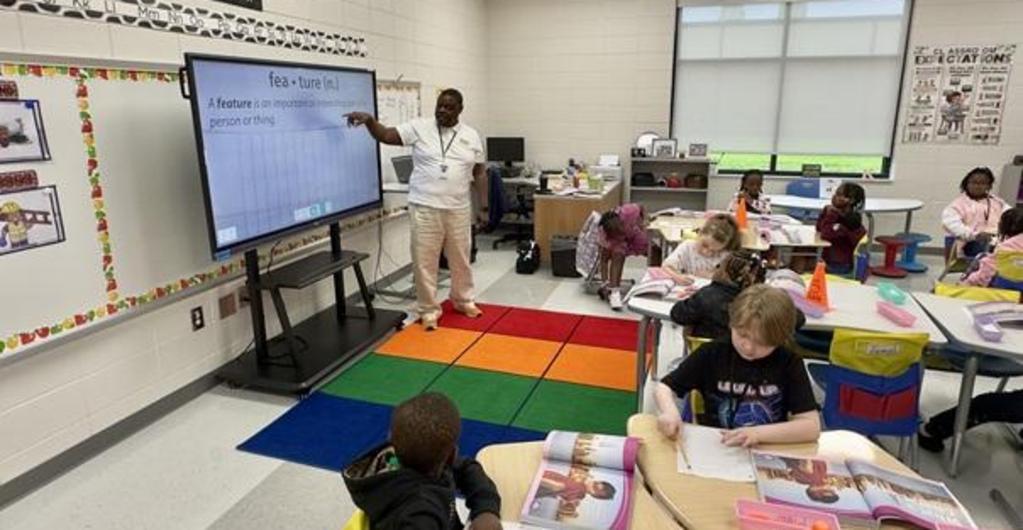Third grade teacher using a smart board in his reading lesson