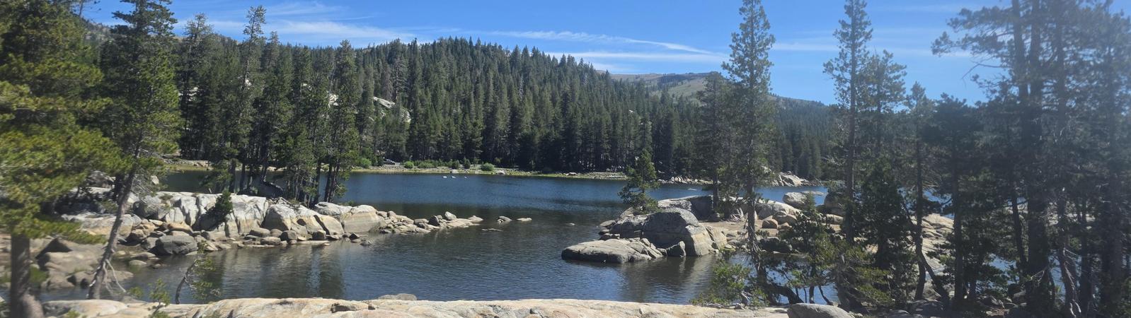 mountain lake with rock and pine trees