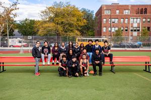 Cross Country Track team andcoaches posing together at Newtown Field.