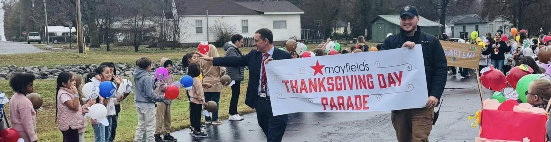 Mr. Edwards and Officer Crane carried the banner to begin the Mayfield's Thanksgiving Day Parade.