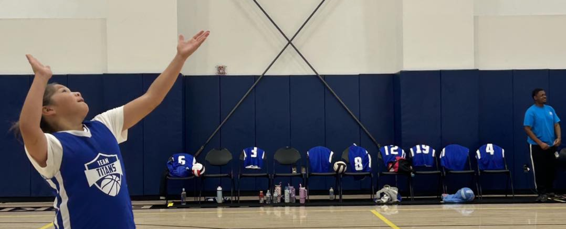 a student preparing to serve a volleyball