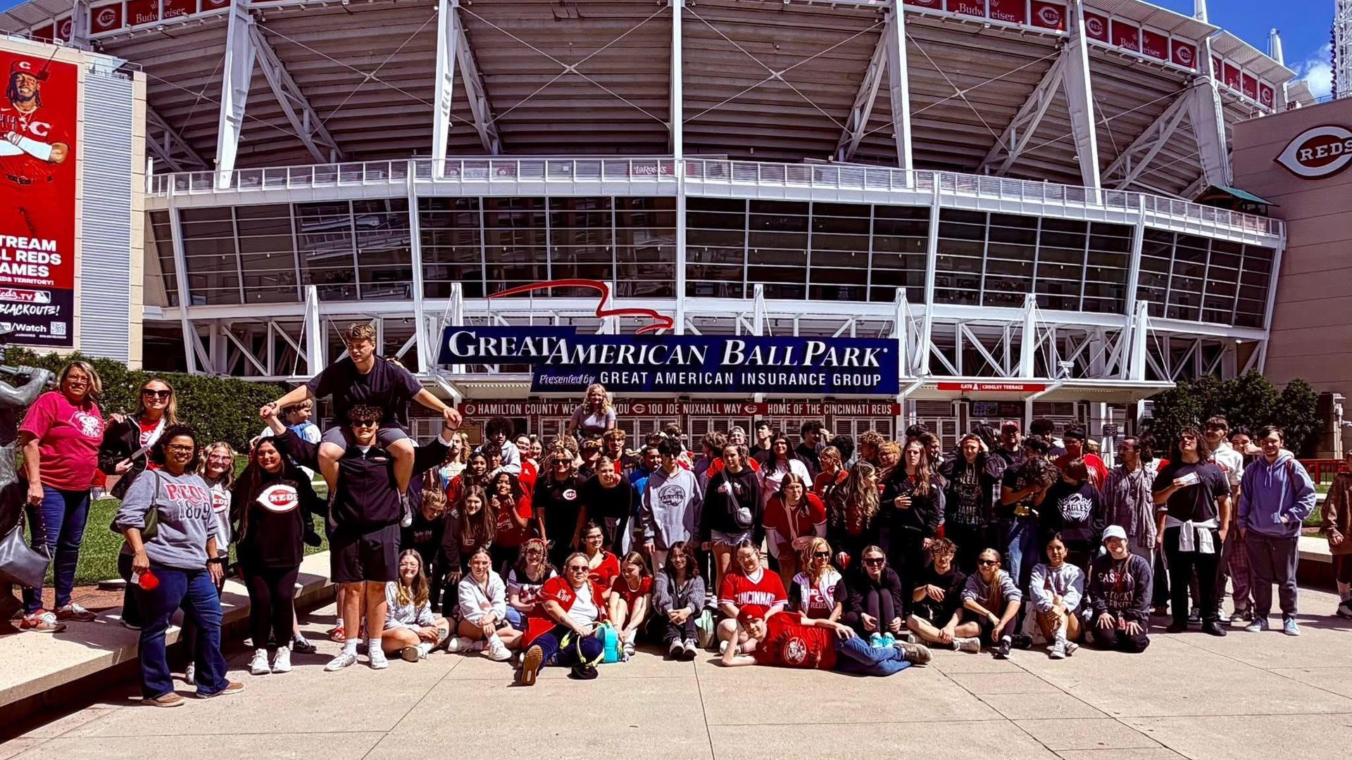 A group of students in front of a baseball stadium