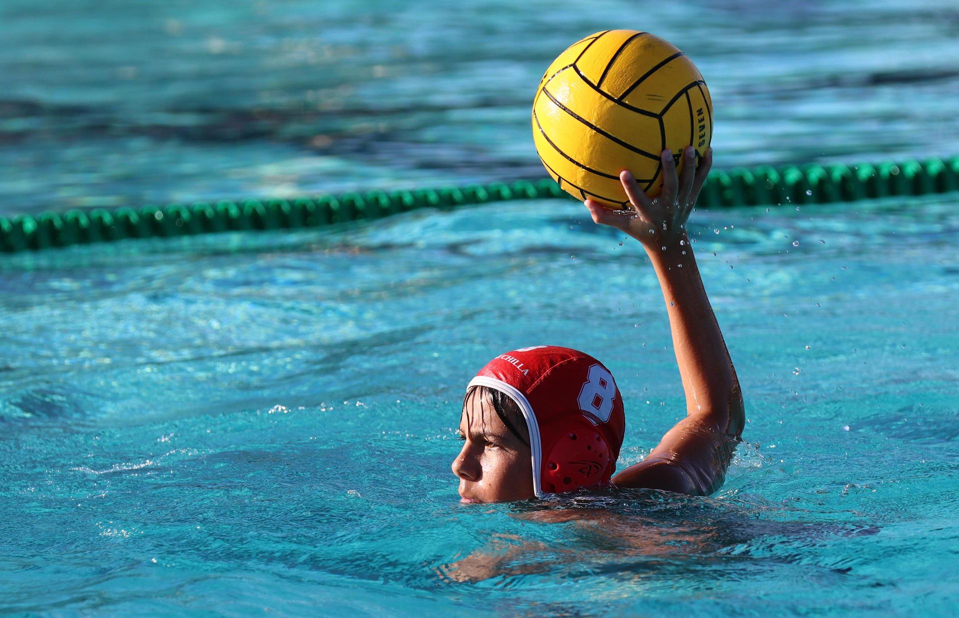 boys water polo players in action against hoover