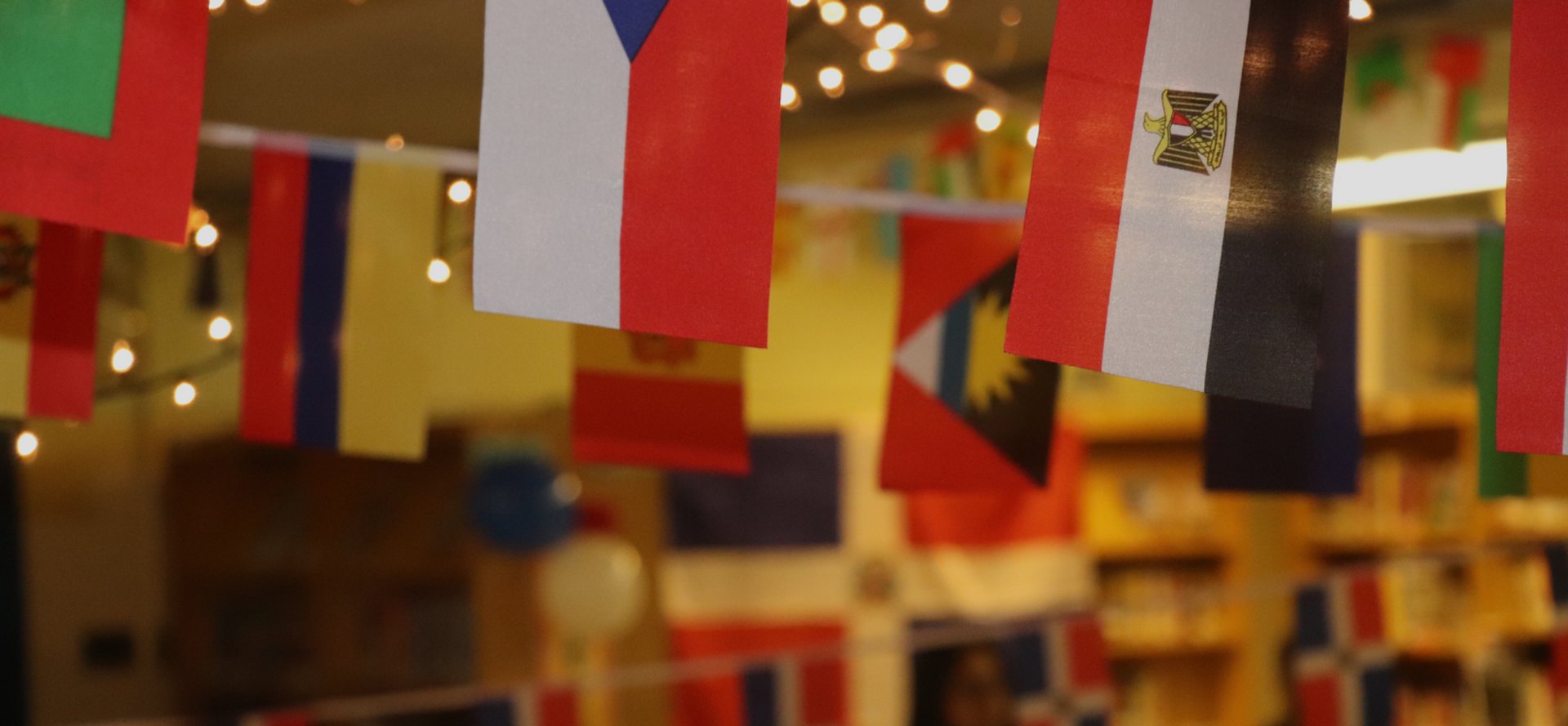 Colorful flags hanging in a decorated indoor space.