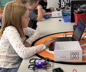 Students working with drones in a STEAM classroom.