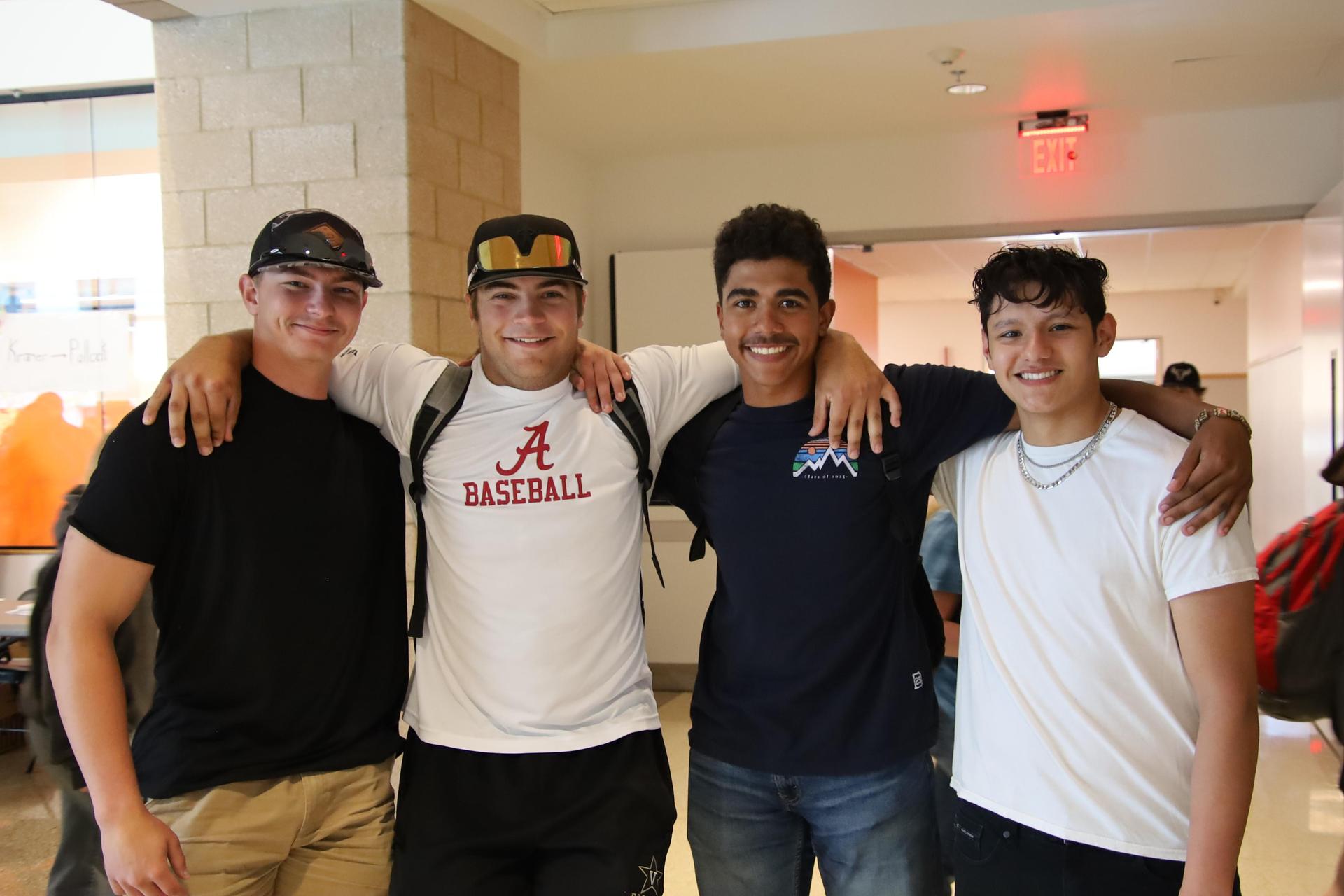 four high school boys posing and smiling for the camera