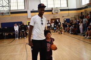 Dybantsa signs a basketball for a child