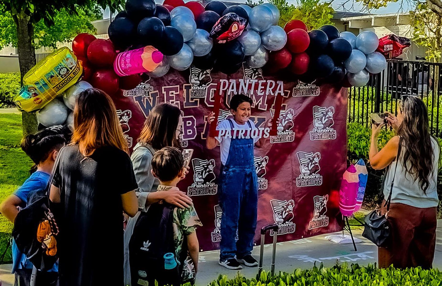 students at photo buuth with PANTERA logos as props