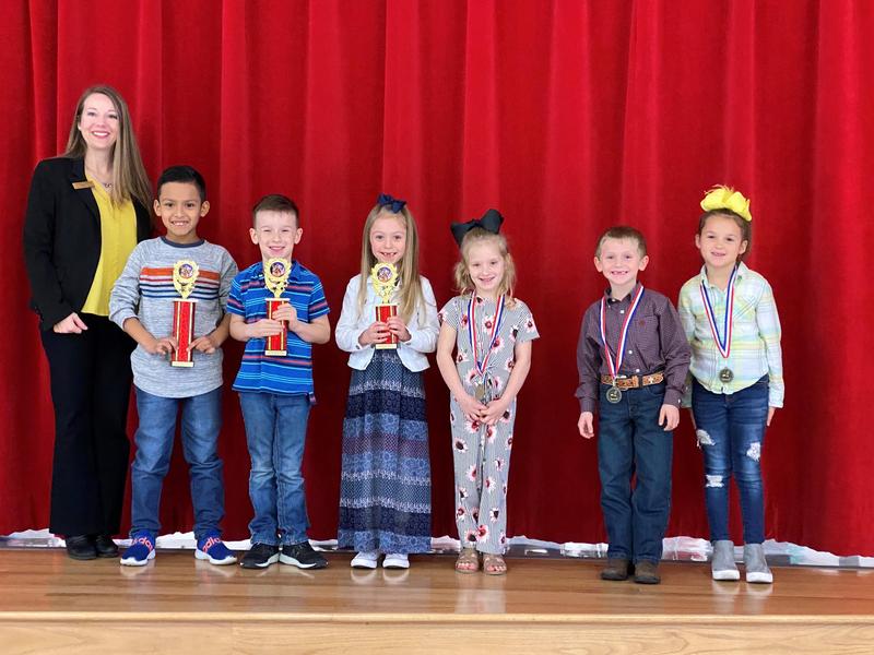 Principal, Mrs. Fowler pictured with spelling bee winners 1st through 6th places with their trophies and medals